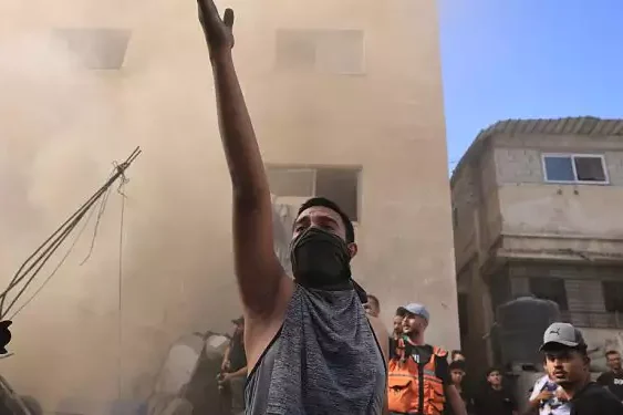 A Palestinian man reacts as others check the rubble of a building in Khan Yunis on November 6, 2023 Photo AFPMahmud Hams