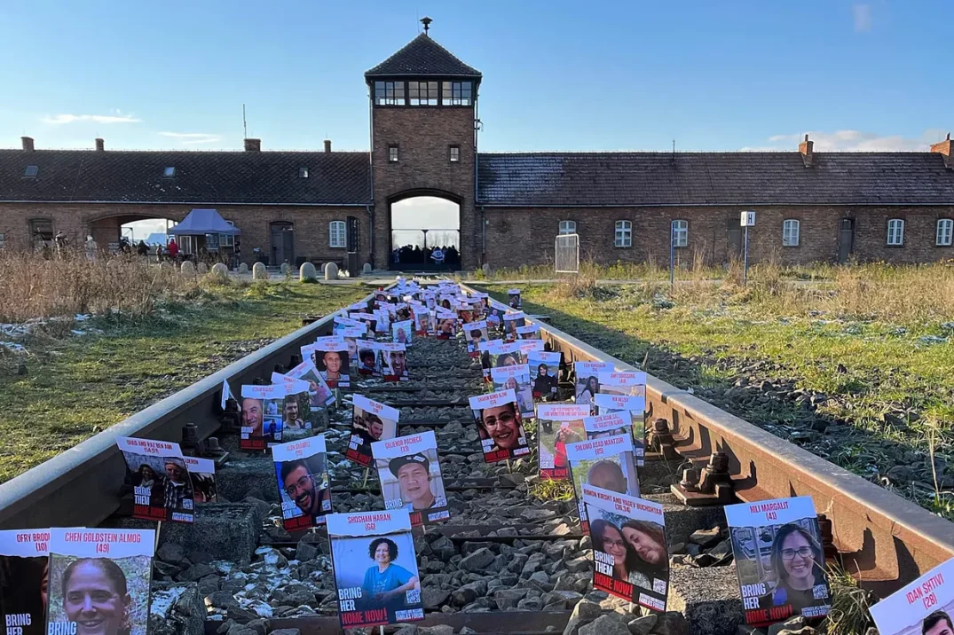 Hostage posters placed on the tracks outside of Auschwitz by students from JFS school in London (JRoots)