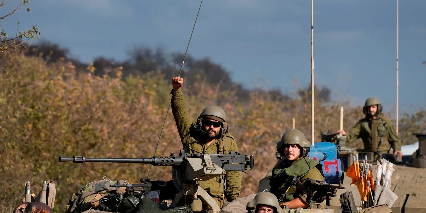 An Israeli soldier raises his fist from a moving APC (AP Photo/Baz Ratner)